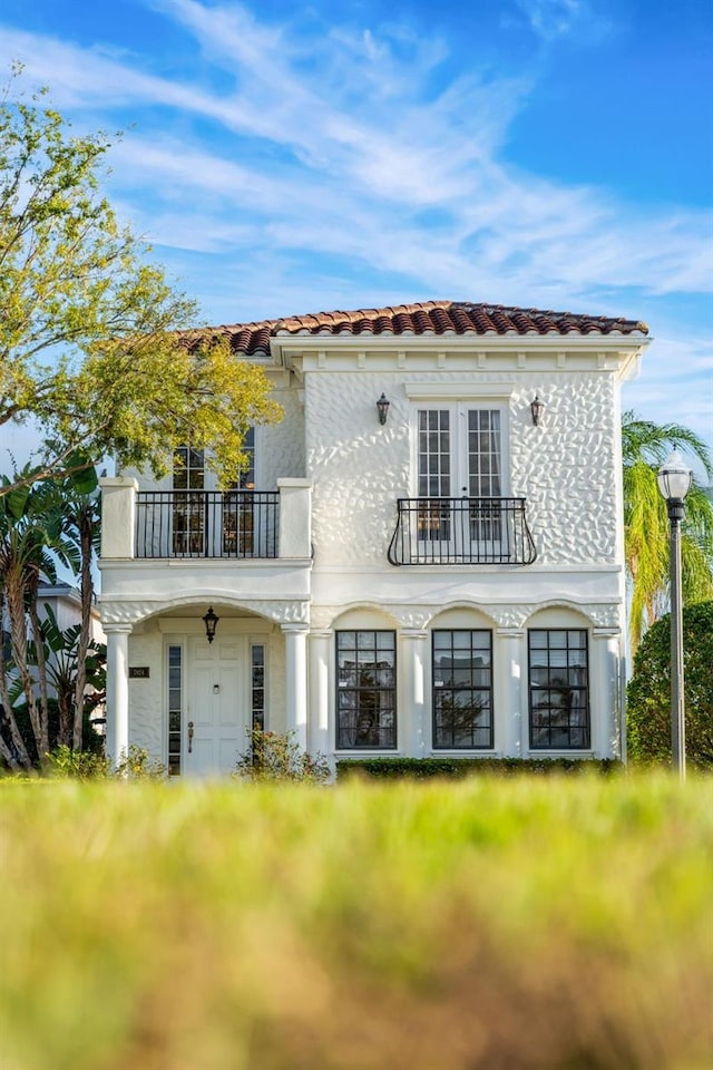 rear view of house with a balcony and french doors