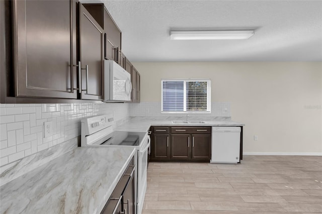 kitchen with sink, white appliances, light stone countertops, a textured ceiling, and decorative backsplash