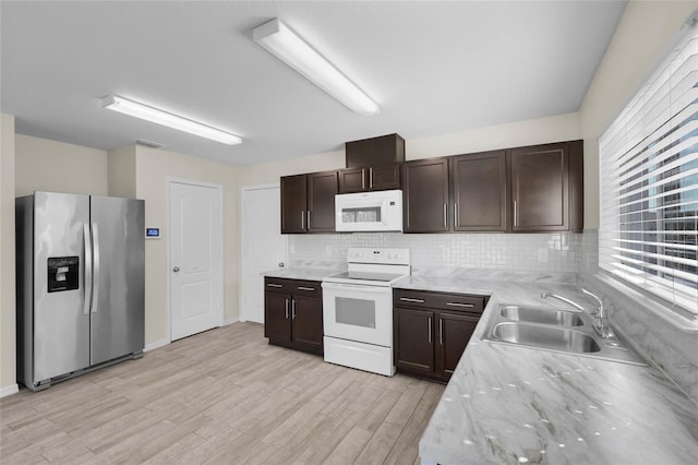 kitchen featuring sink, tasteful backsplash, dark brown cabinets, light wood-type flooring, and white appliances