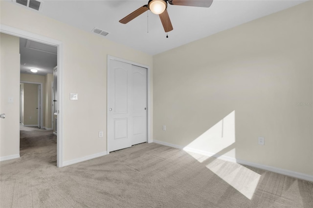 unfurnished bedroom with ceiling fan, light colored carpet, and a closet