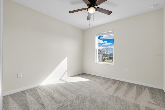 spare room featuring light colored carpet and ceiling fan