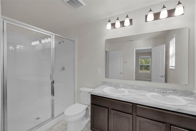 bathroom with an enclosed shower, vanity, and toilet