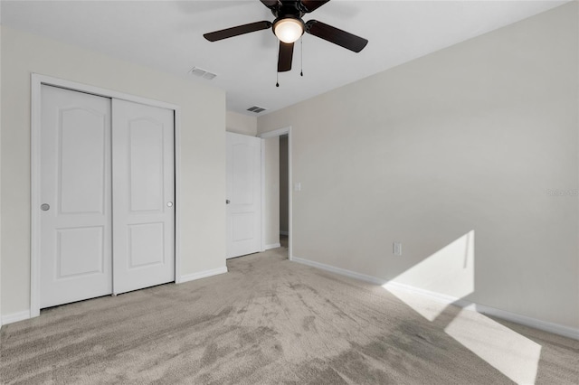 unfurnished bedroom with light colored carpet, a closet, and ceiling fan