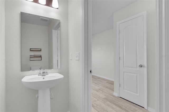 bathroom featuring sink, wood-type flooring, and toilet