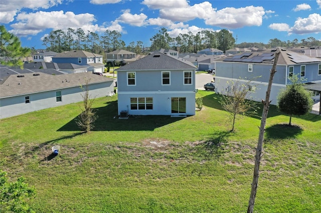 rear view of property with cooling unit and a lawn