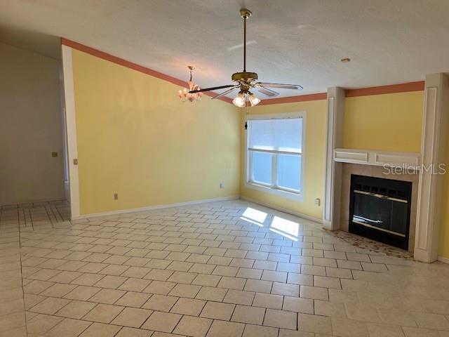 unfurnished living room with ceiling fan and light tile patterned floors