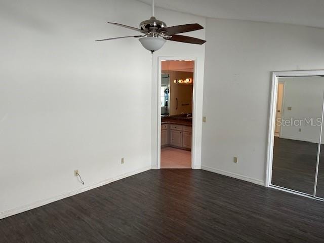 spare room featuring dark wood-type flooring, ceiling fan, and lofted ceiling