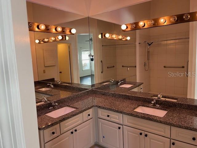 bathroom featuring vanity and tiled shower