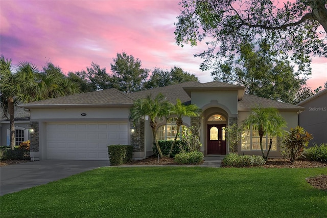 mediterranean / spanish house featuring a lawn and a garage