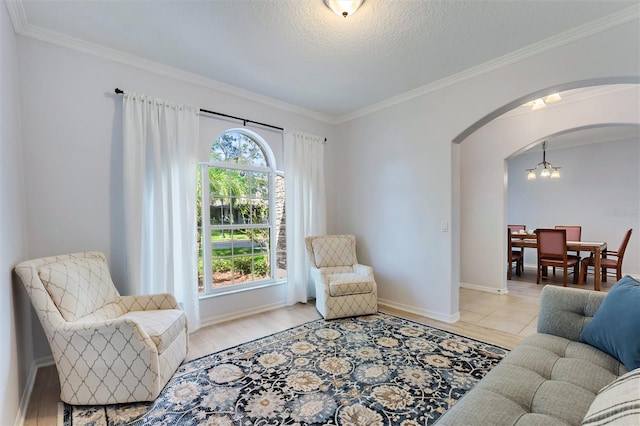 sitting room with a wealth of natural light, crown molding, and light hardwood / wood-style flooring