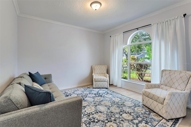 living room featuring a textured ceiling, light wood-type flooring, and ornamental molding