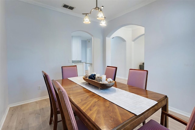 dining room with light hardwood / wood-style flooring and ornamental molding