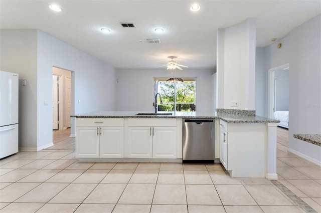 kitchen featuring kitchen peninsula, light stone counters, stainless steel dishwasher, sink, and white cabinets