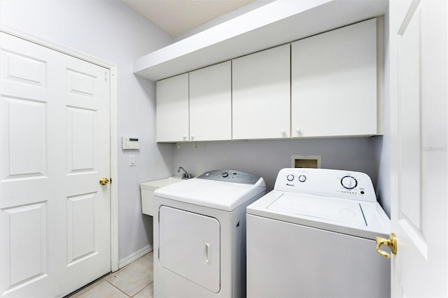 clothes washing area featuring washing machine and clothes dryer, sink, light tile patterned flooring, and cabinets