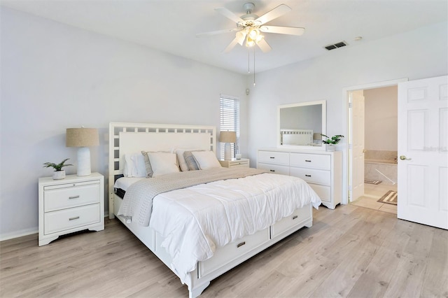 bedroom featuring ceiling fan, ensuite bathroom, and light wood-type flooring