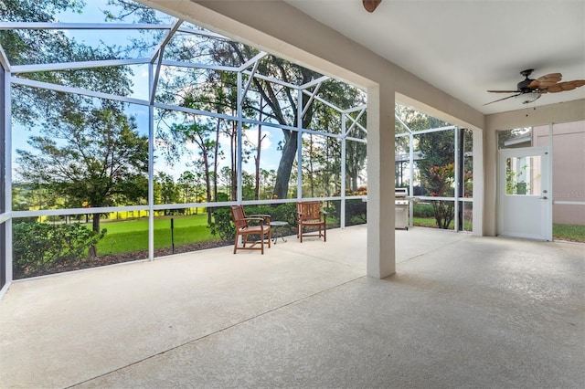 view of patio with glass enclosure and ceiling fan