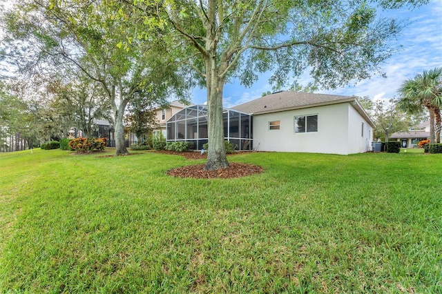 back of property with a lanai, a lawn, and cooling unit