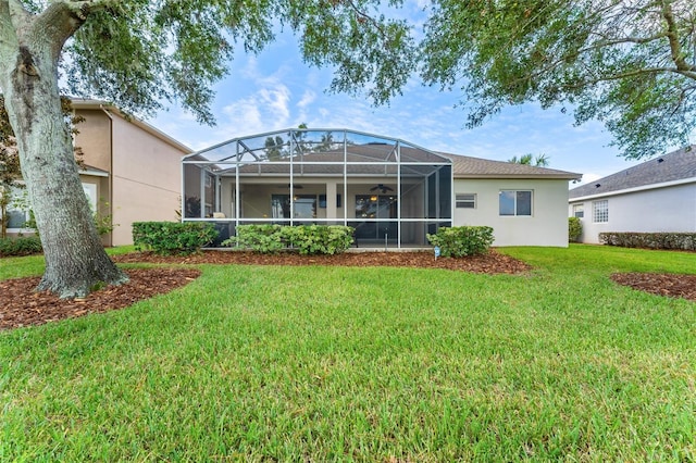 rear view of property featuring a lanai and a lawn