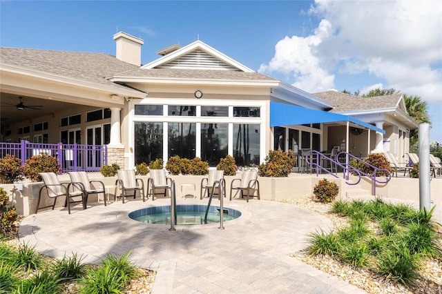 rear view of house featuring a patio area and a community hot tub