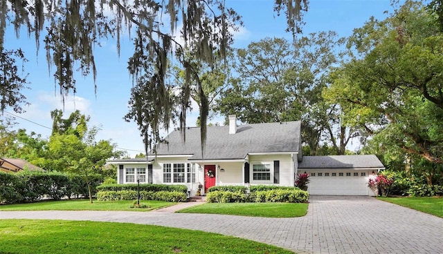 cape cod-style house featuring a front lawn and a garage