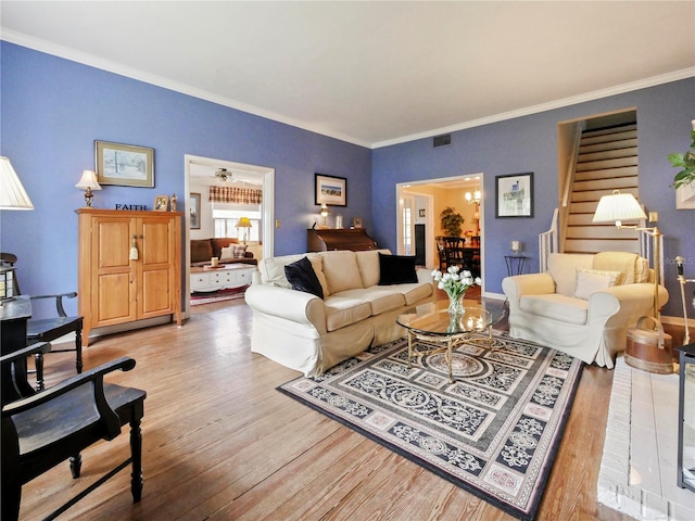 living room with ornamental molding and light wood-type flooring