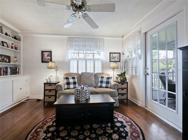 living room featuring ceiling fan, dark wood-type flooring, and ornamental molding