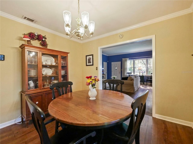 dining room featuring a chandelier, dark wood-type flooring, and ornamental molding