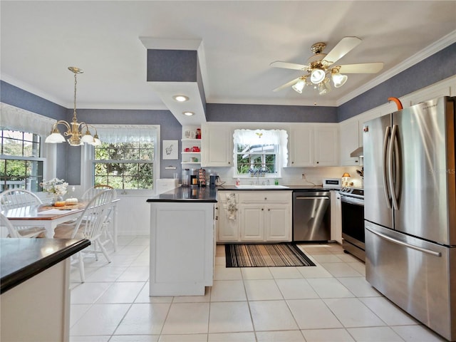 kitchen featuring white cabinetry, hanging light fixtures, crown molding, ceiling fan with notable chandelier, and appliances with stainless steel finishes