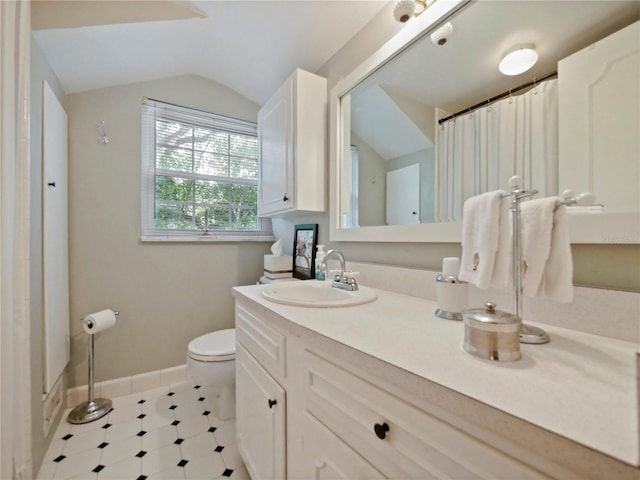 bathroom with vanity, toilet, and vaulted ceiling