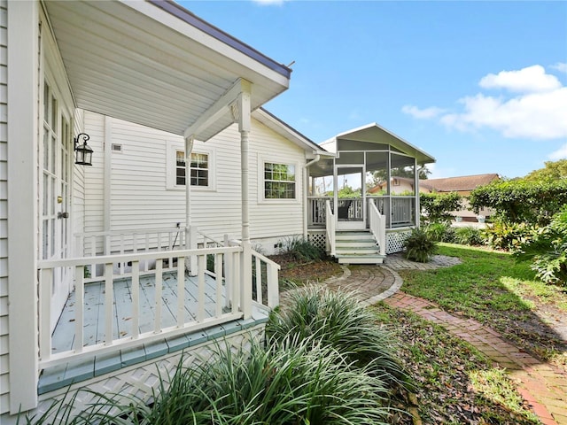 rear view of property with a deck and a sunroom