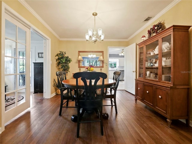 dining space with crown molding, dark wood-type flooring, and ceiling fan with notable chandelier