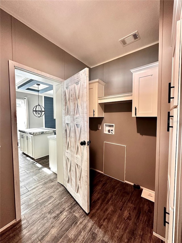 laundry room featuring hookup for a washing machine, cabinets, a textured ceiling, and hardwood / wood-style flooring