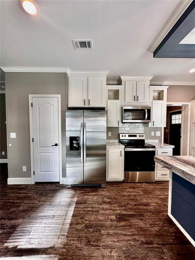 kitchen featuring appliances with stainless steel finishes, a textured ceiling, crown molding, white cabinets, and dark hardwood / wood-style floors