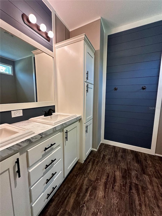 bathroom with crown molding, vanity, wood-type flooring, and a textured ceiling