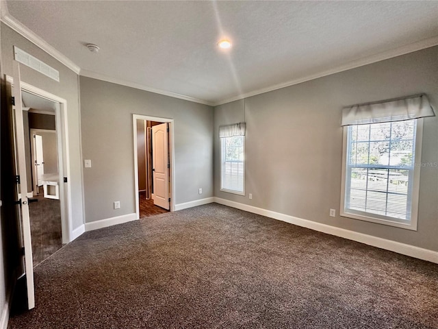 unfurnished bedroom with a textured ceiling, connected bathroom, dark carpet, and ornamental molding