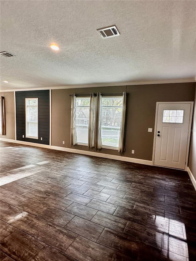 entrance foyer featuring crown molding, dark wood-type flooring, and a textured ceiling