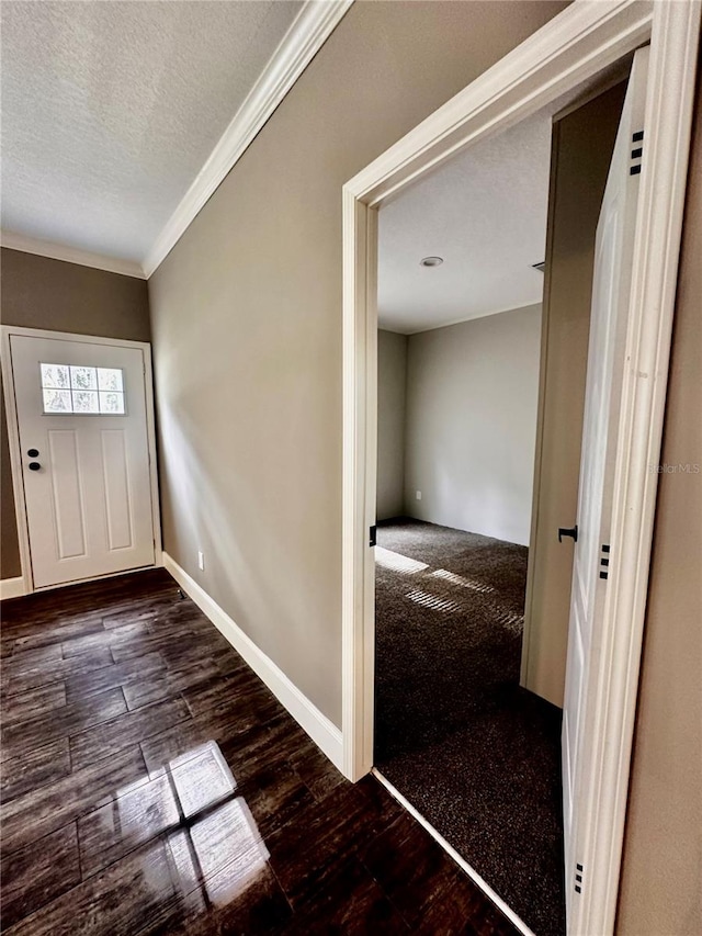 foyer entrance featuring a textured ceiling, dark hardwood / wood-style floors, and crown molding