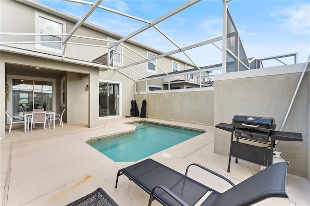 view of pool featuring glass enclosure and a patio area