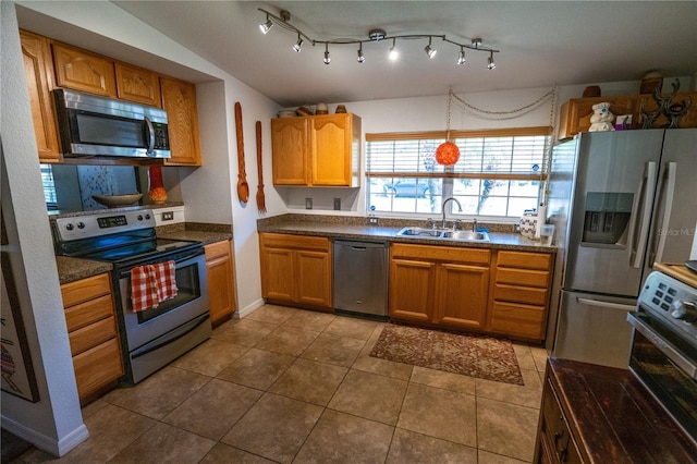 kitchen with tile patterned floors, pendant lighting, sink, and stainless steel appliances