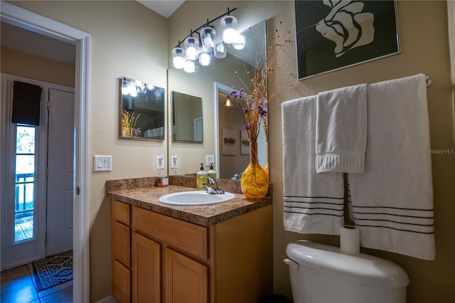 bathroom with tile patterned flooring, vanity, and toilet