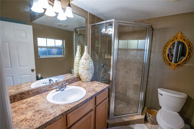 bathroom featuring vanity, toilet, an enclosed shower, and a textured ceiling