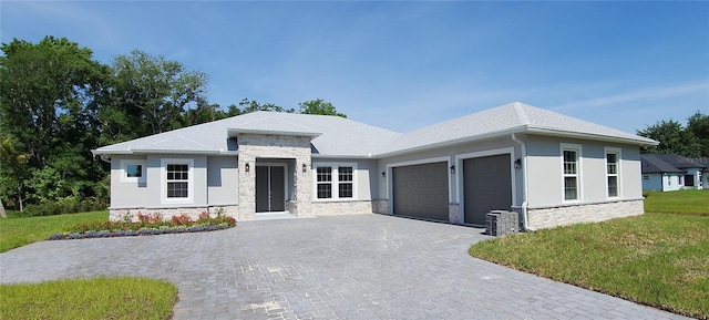 prairie-style house featuring a garage and a front lawn