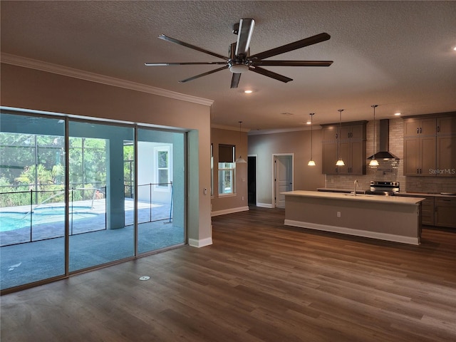 unfurnished living room featuring ceiling fan, dark hardwood / wood-style flooring, a textured ceiling, and ornamental molding