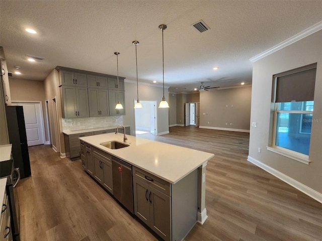 kitchen with stainless steel dishwasher, ceiling fan, dark wood-type flooring, sink, and a center island with sink