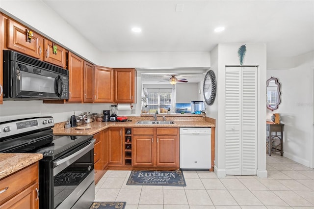 kitchen featuring dishwasher, stainless steel range with electric cooktop, sink, light tile patterned floors, and light stone counters