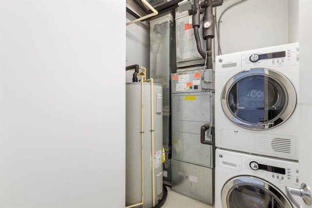 clothes washing area featuring water heater and stacked washer and dryer