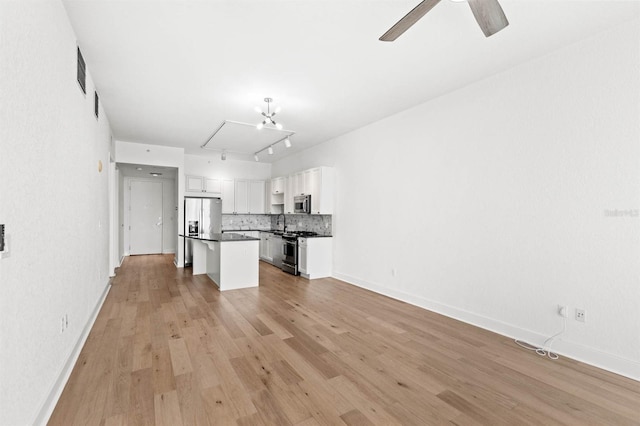 unfurnished living room with ceiling fan, sink, and light hardwood / wood-style flooring