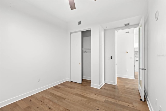 unfurnished bedroom featuring a closet, light hardwood / wood-style flooring, and ceiling fan