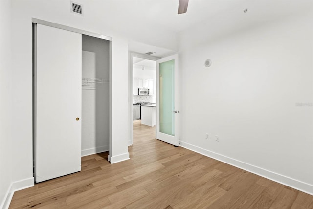 unfurnished bedroom featuring a closet, ceiling fan, and light hardwood / wood-style flooring