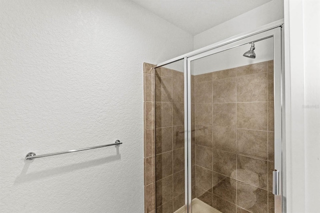 bathroom featuring a shower with shower door